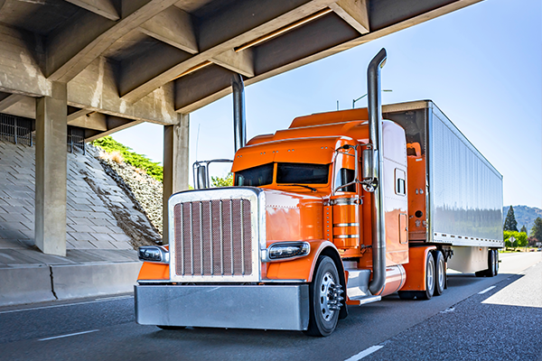 carrier semi truck under a bridge on the freeway